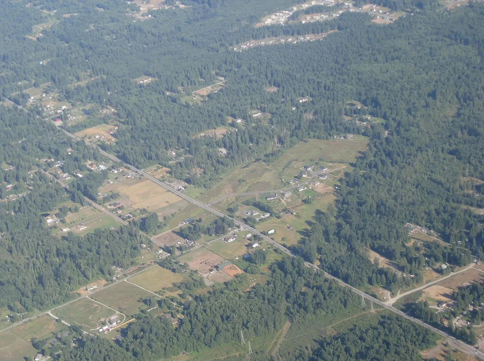 Aerial view of acreage north of Lake Stevens, WA: pastures, outbuildings and homes set into second-growth forest