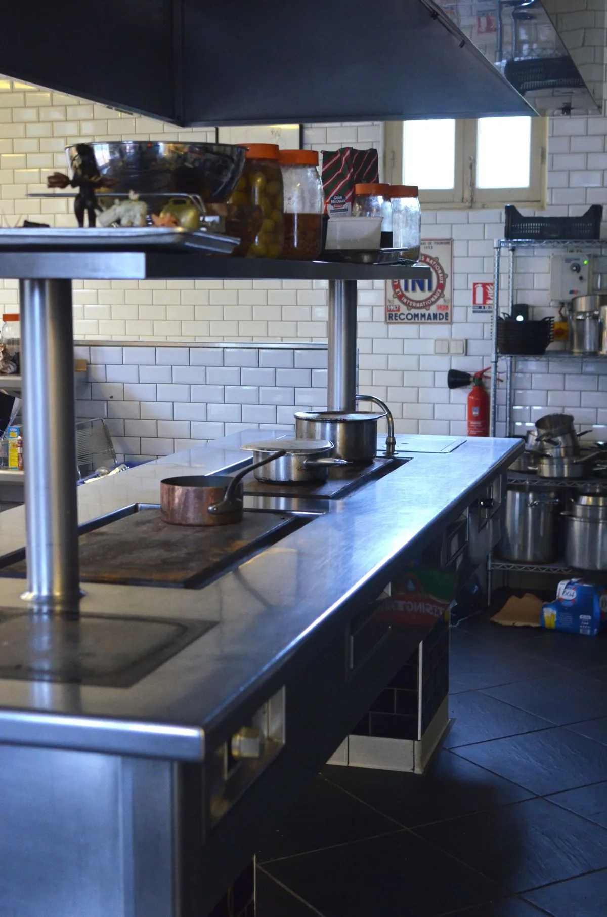 Empty commercial kitchen with stainless steel surfaces and subway tile