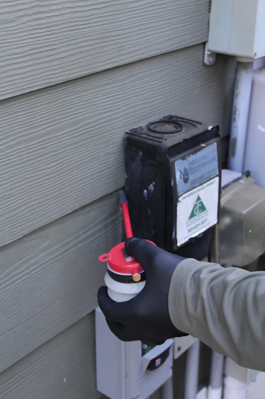 Pure Guard technician servicing a tamper-resistant rodent bait station outside a Snohomish County, WA home