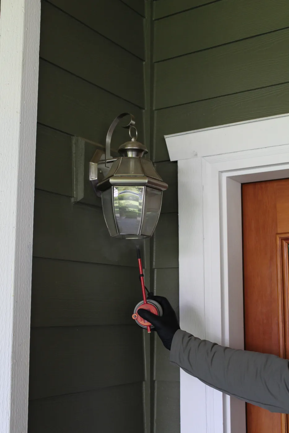 Pure Guard technician treating eaves and a light fixture where wasps and yellow jackets nest in Edmonds, WA