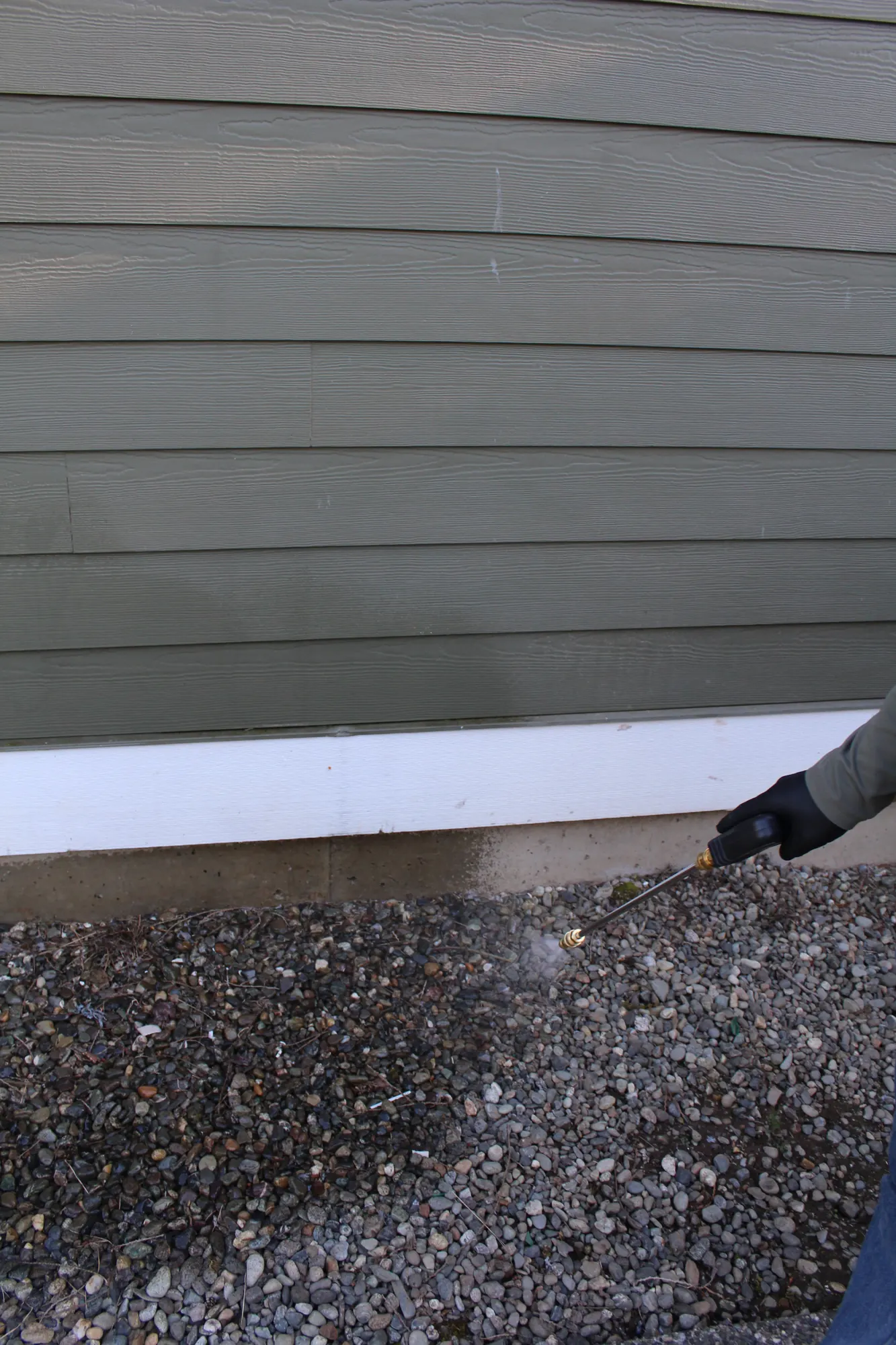 Pure Guard technician treating along the foundation line and crawl space vents of an Everett, WA home